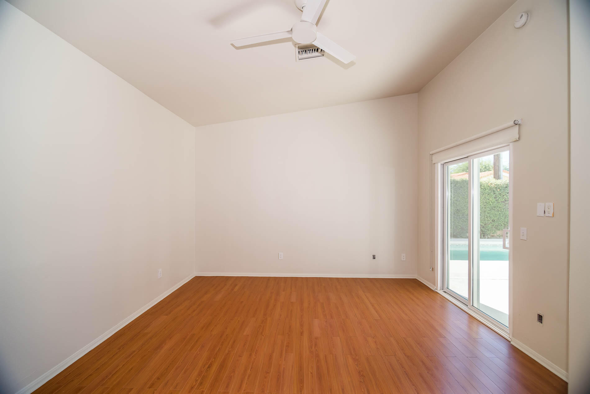 67685 Garbino Road Cathedral City, CA 92234 - Photo 20 of 45 an empty room with wooden floor and windows