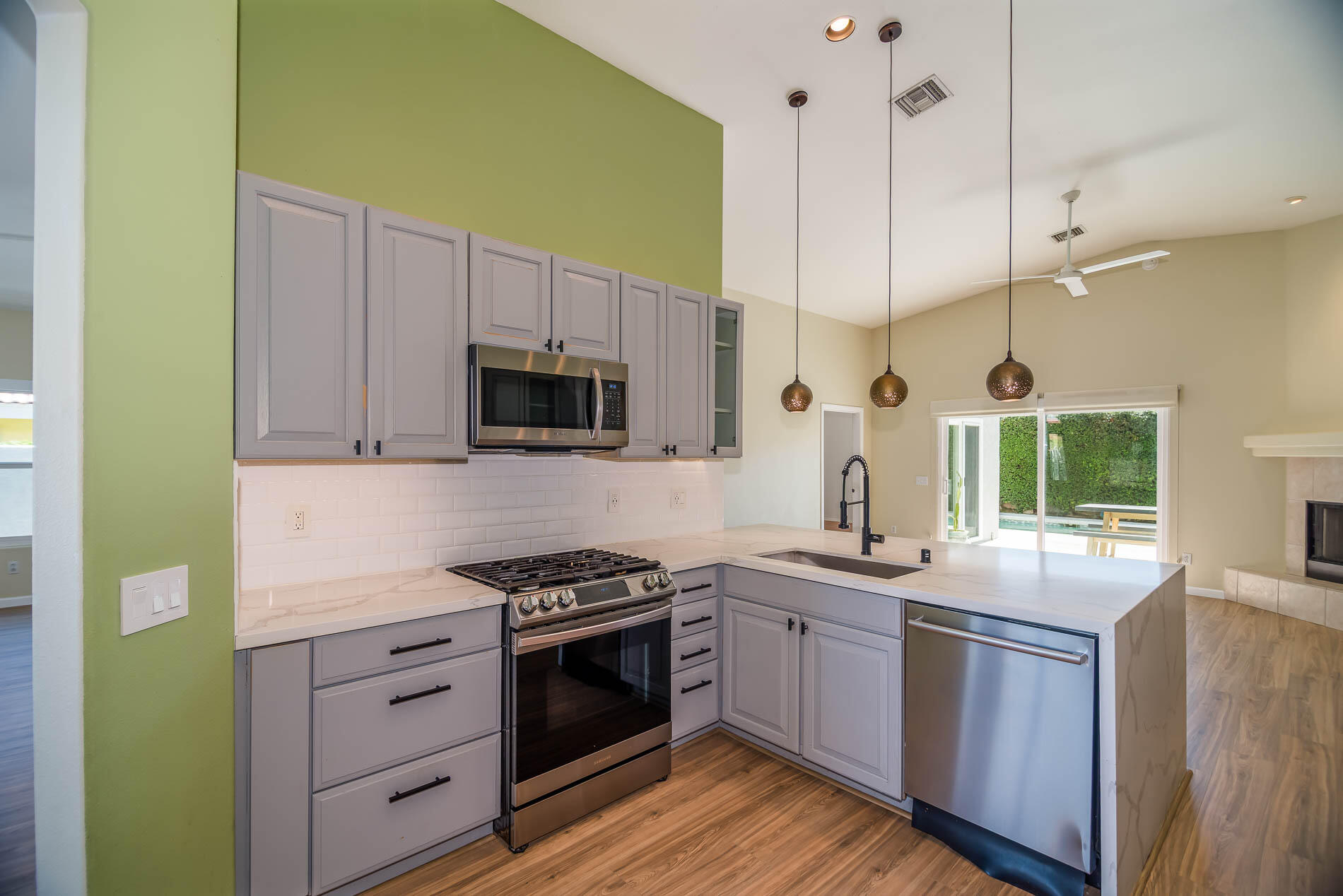 67685 Garbino Road Cathedral City, CA 92234 - Photo 2 of 45 a kitchen with stainless steel appliances granite countertop a sink a stove and a wooden floors