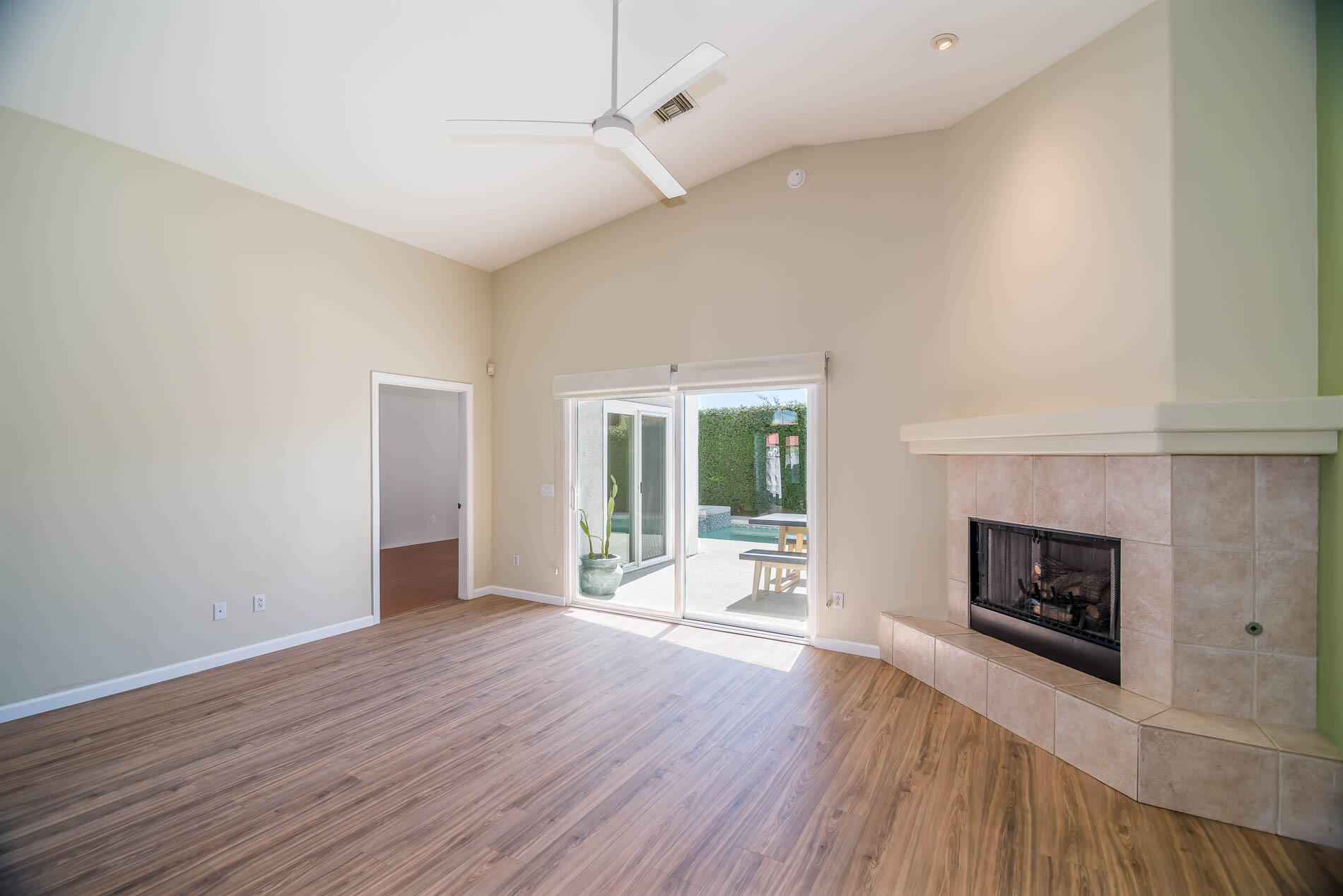 67685 Garbino Road Cathedral City, CA 92234 - Photo 26 of 45 an empty room with wooden floor fireplace and windows