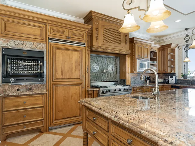 a kitchen with stainless steel appliances granite countertop a stove a sink and a microwave