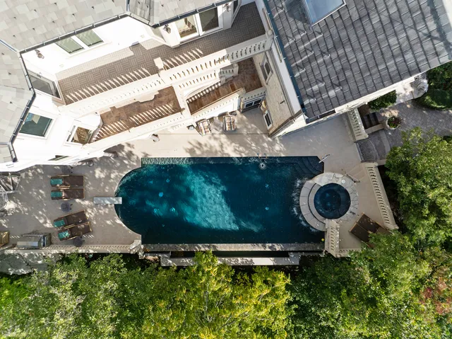 an aerial view of a backyard with chairs and a fire pit
