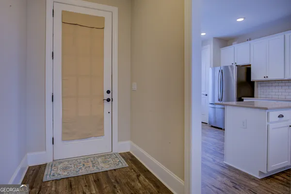 a view of a hallway with wooden floor and entryway