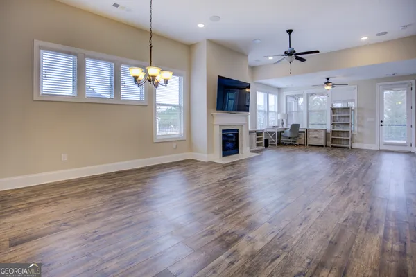 a view of a room with wooden floor and chandelier