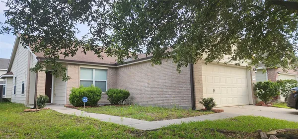a front view of a house with a yard and tree