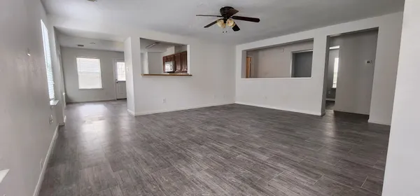 a view of empty room with wooden floor and windows