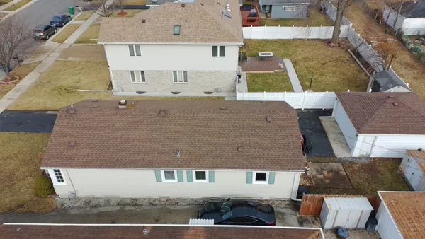 an aerial view of a house with a yard