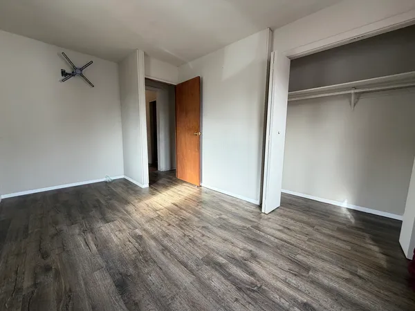 a view of an empty room with wooden floor