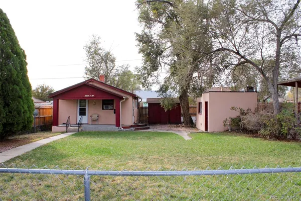 a view of a house with a yard and tree