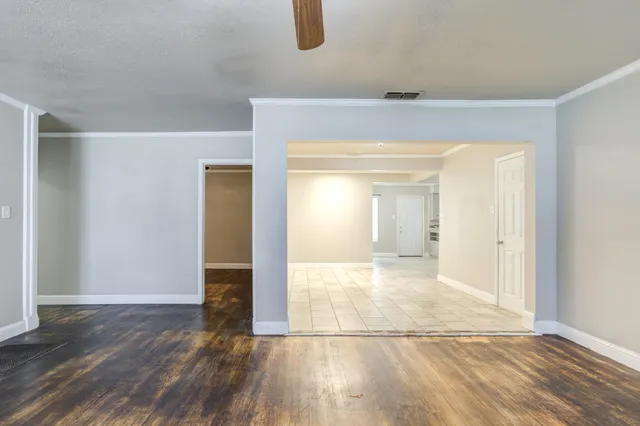 an empty room with fireplace and wooden floor