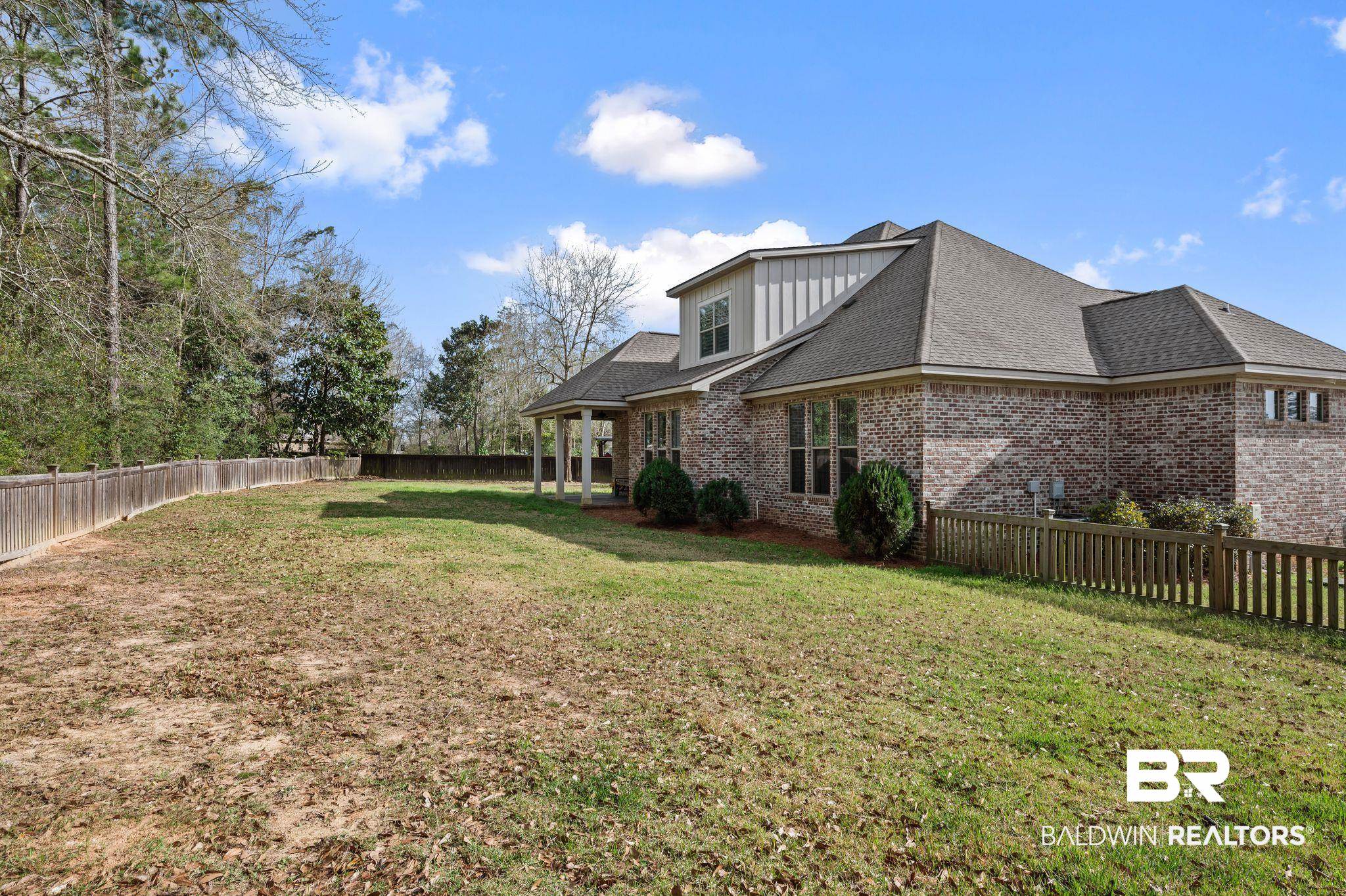 32194 Badger Court Daphne, AL 36527 - Photo 41 of 49 View of property exterior featuring a fenced backyard, brick siding, roof with shingles, and board and batten siding