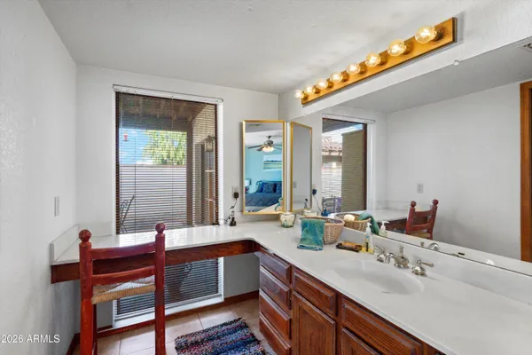 a bathroom with a sink mirror and a window