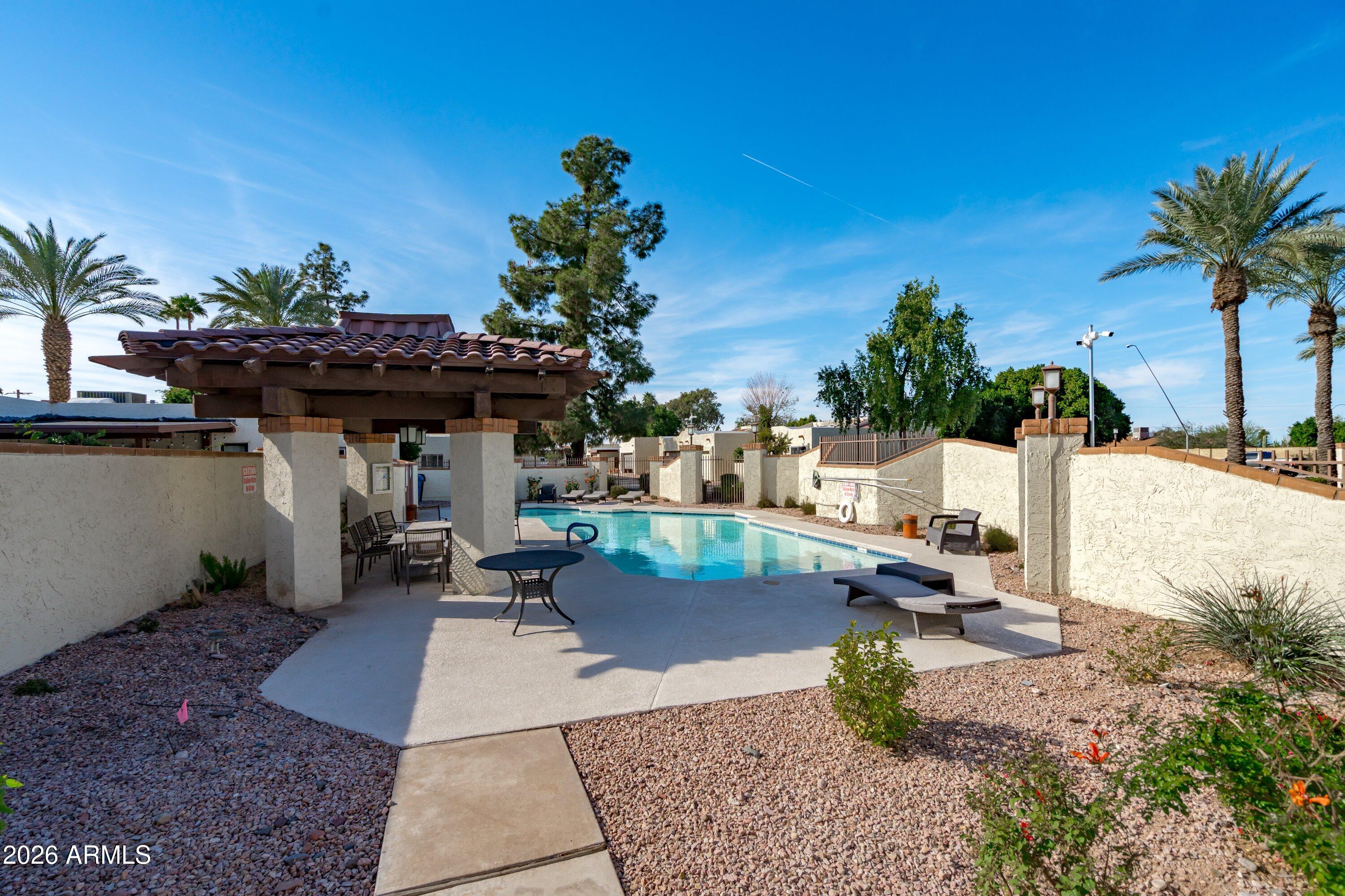 1301 West Rio Salado Parkway, Unit 22 Mesa, AZ 85201 - Photo 21 of 21 a view of a patio with table and chairs potted plants with wooden fence
