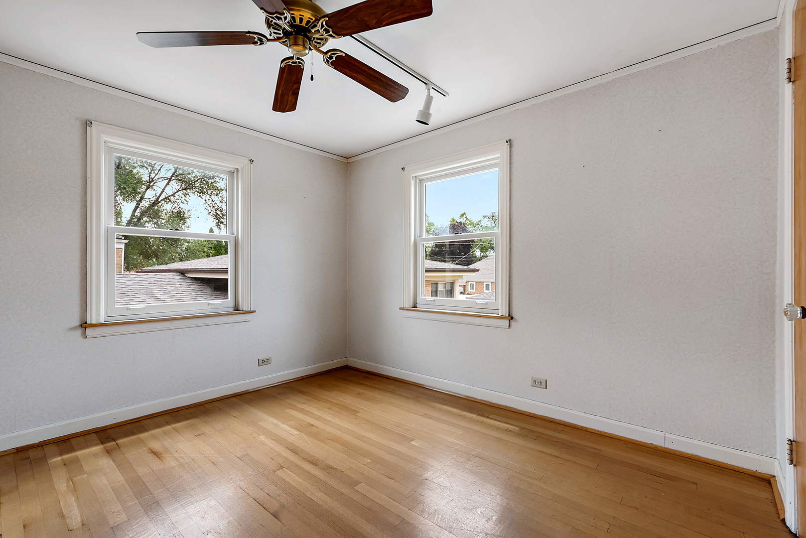 7438 Kenneth Avenue Skokie, IL 60076 - Photo 11 of 17 a view of an empty room with window and wooden floor