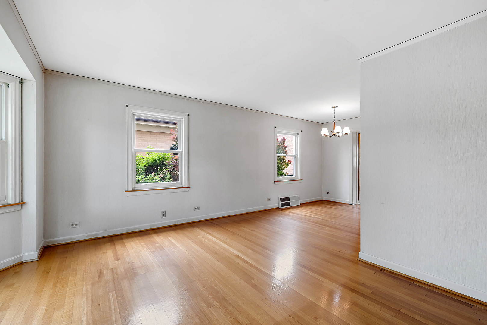 7438 Kenneth Avenue Skokie, IL 60076 - Photo 2 of 17 an empty room with wooden floor and windows