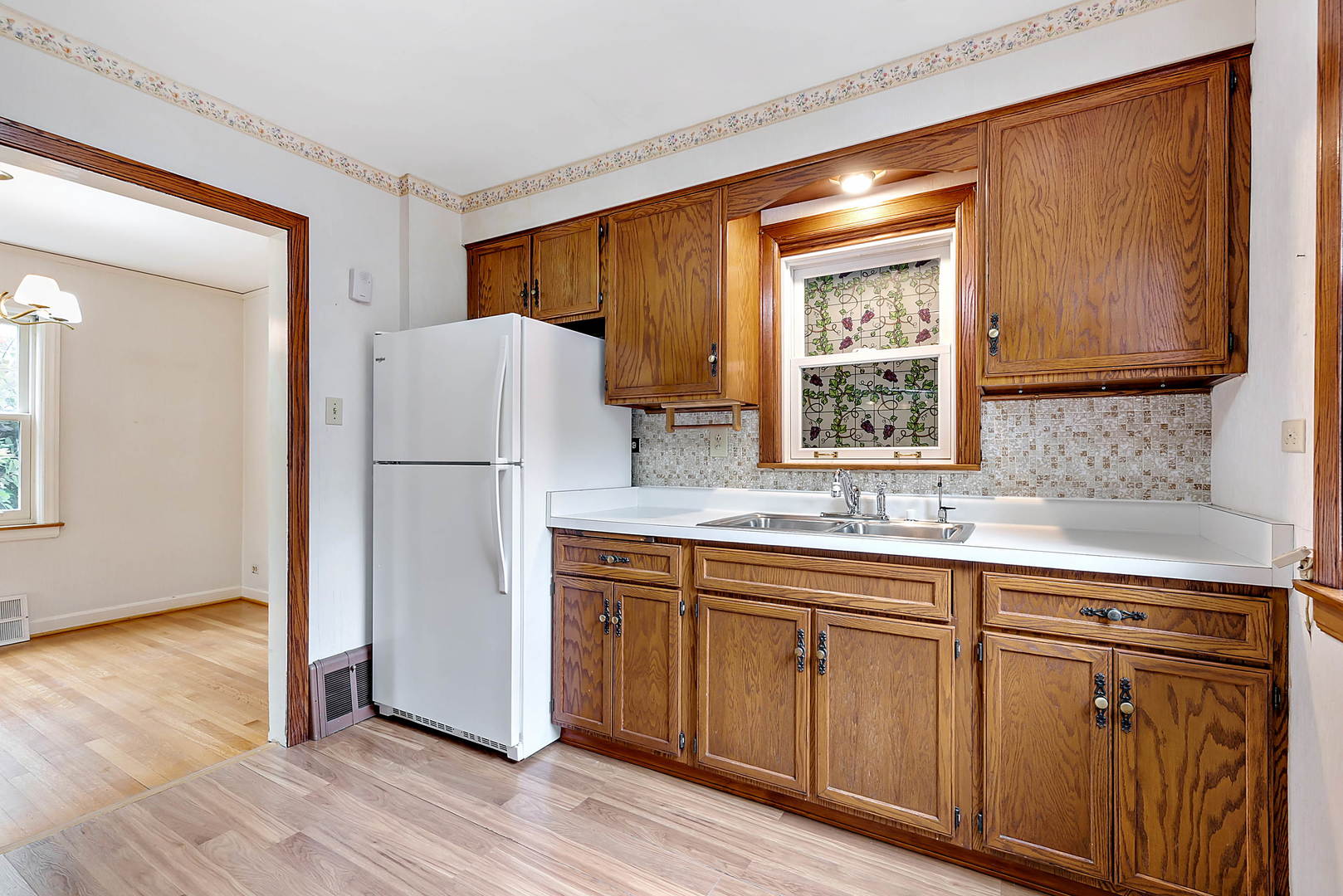 7438 Kenneth Avenue Skokie, IL 60076 - Photo 5 of 17 a kitchen with white cabinets and refrigerator