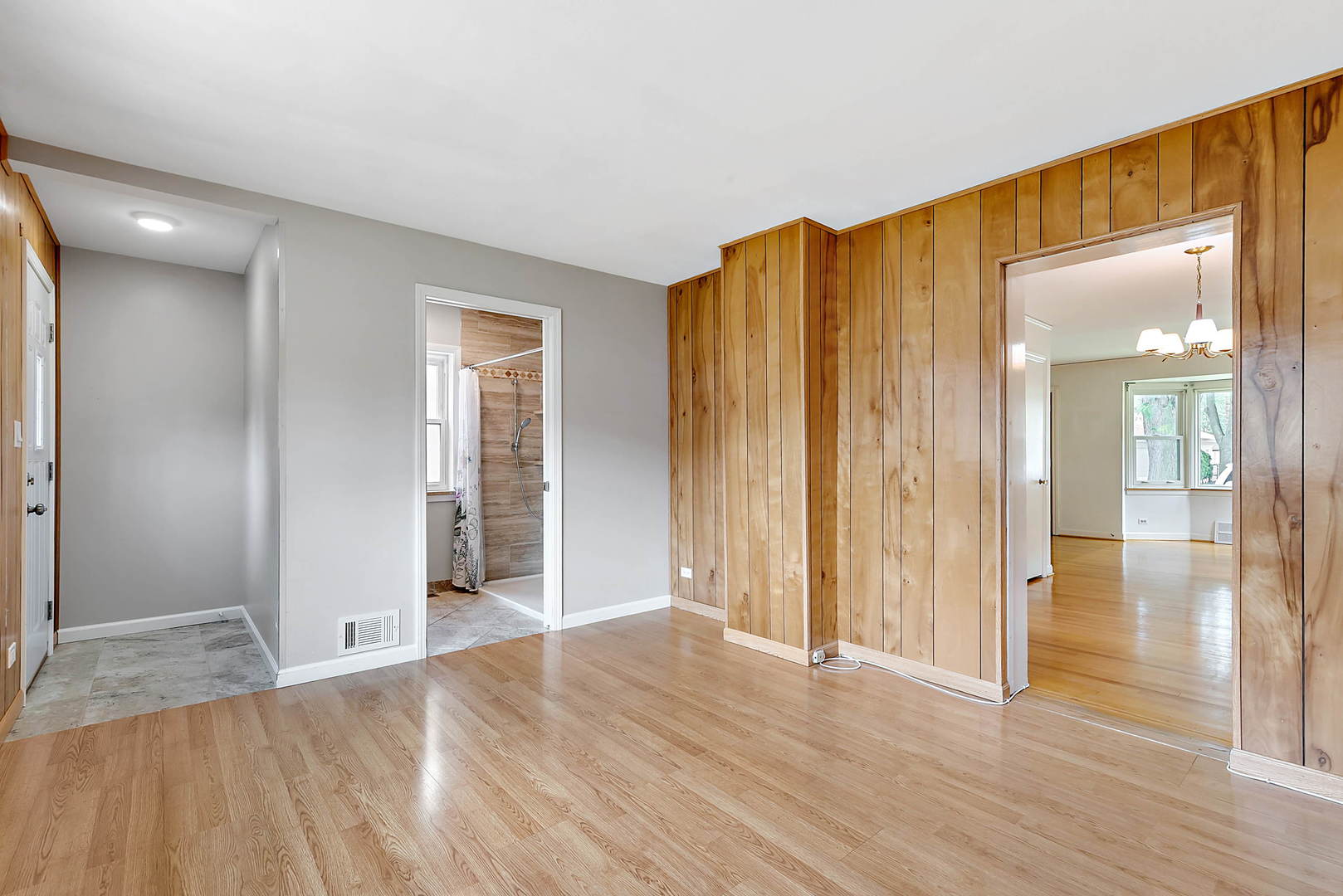 7438 Kenneth Avenue Skokie, IL 60076 - Photo 8 of 17 an empty room with wooden floor and a bathroom