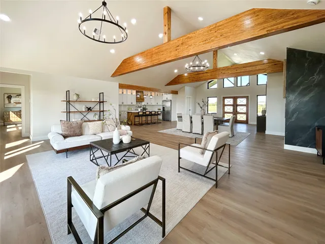 a living room with furniture kitchen view and a wooden floor