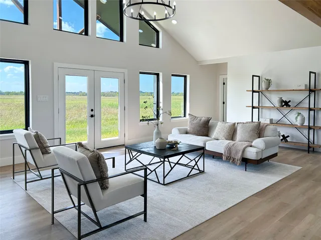 a living room with furniture and floor to ceiling windows