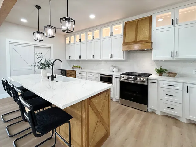 a kitchen with a sink a stove and cabinets