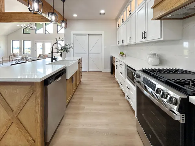 a kitchen with stainless steel appliances granite countertop a sink stove and cabinets