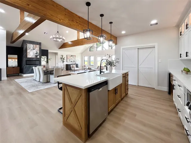 a kitchen with stainless steel appliances a sink a counter top space cabinets and wooden floor