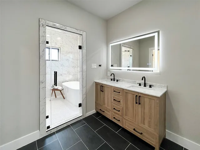 a bathroom with a double vanity sink mirror and bathtub