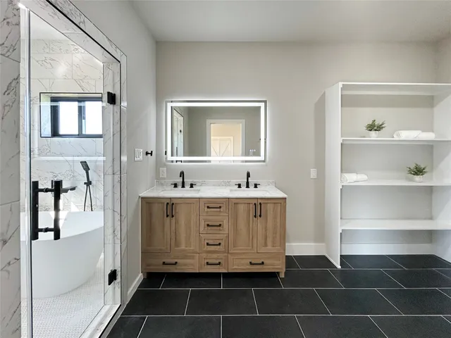 a bathroom with a double vanity sink mirror and bathtub