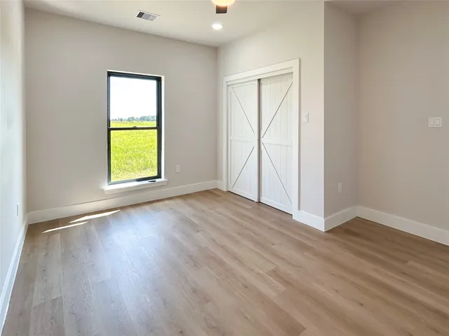 an empty room with a window and wooden floor
