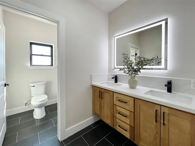 a bathroom with a toilet sink and mirror