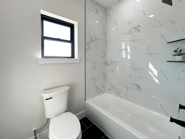 a white toilet sitting next to a bath tub