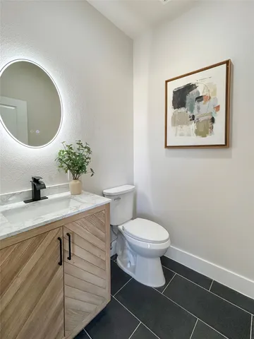 a bathroom with a toilet a sink and mirror