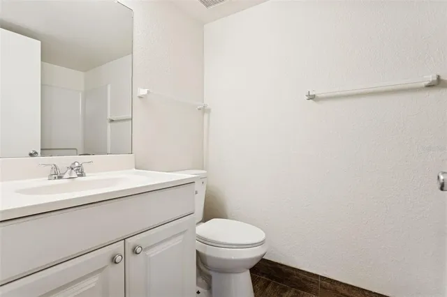 a bathroom with a toilet a sink and mirror