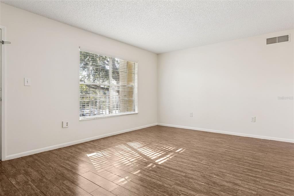 2690 Coral Landings Boulevard, Unit 622 Palm Harbor, FL 34684 - Photo 4 of 31 a view of an empty room with wooden floor and a window