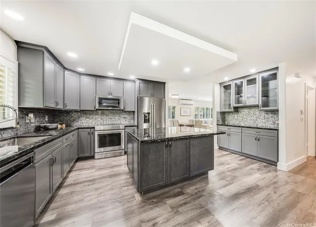 a large kitchen with stainless steel appliances and cabinets