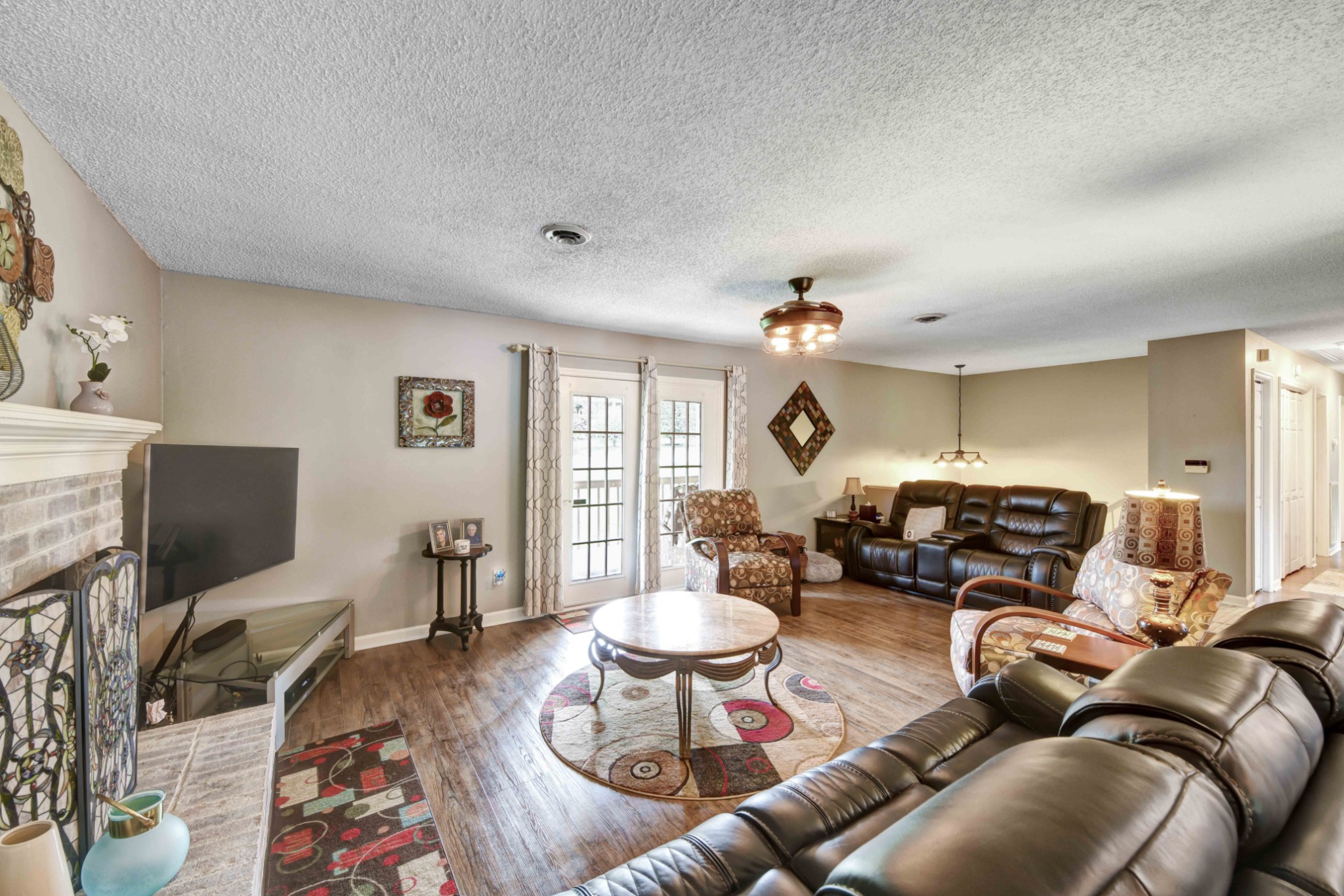 607 Vaughan's Gap Road Spring Hill, TN 37174 - Photo 7 of 34 a living room with furniture a chandelier and a flat screen tv