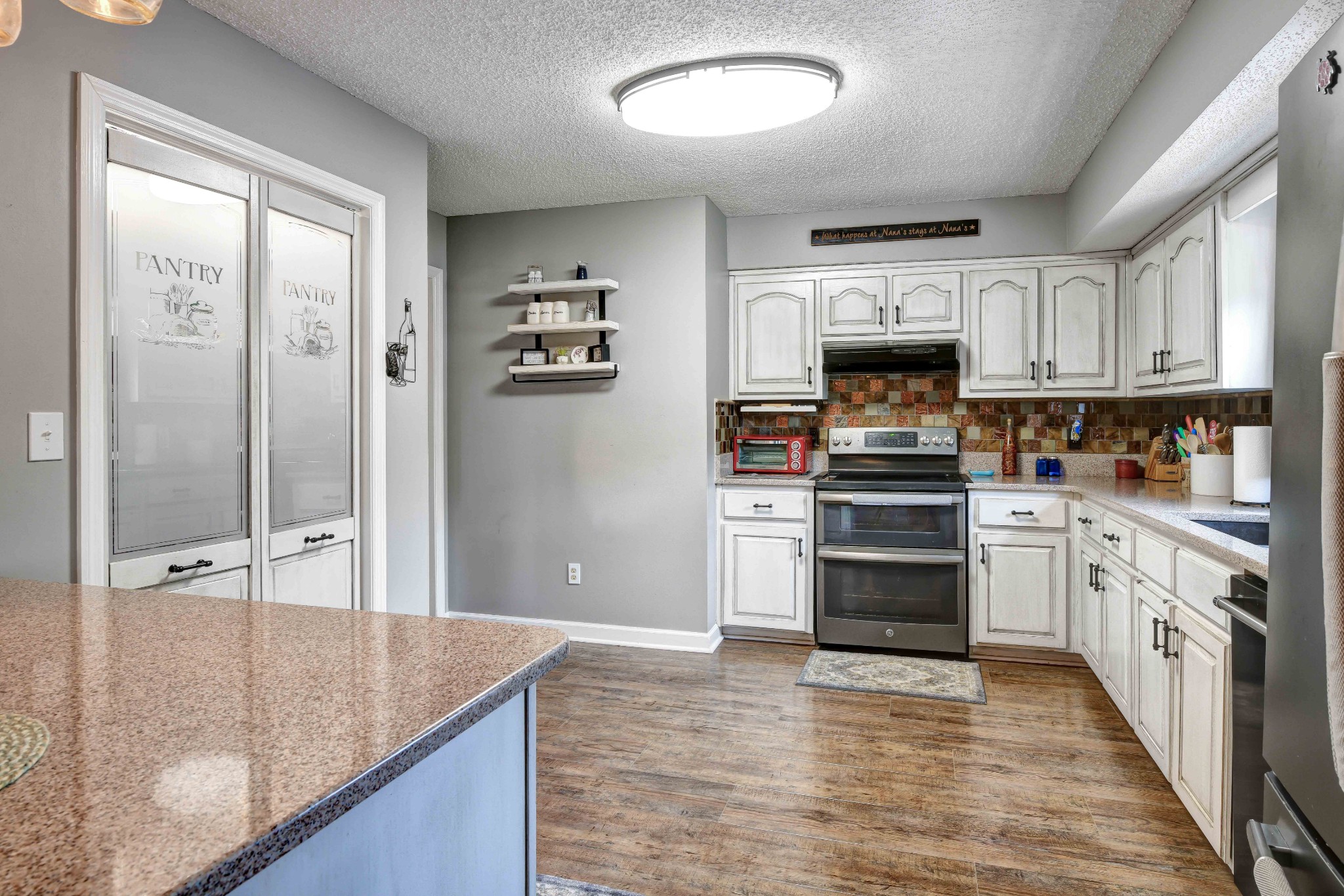 607 Vaughan's Gap Road Spring Hill, TN 37174 - Photo 8 of 34 a kitchen with kitchen island granite countertop a stove and a sink