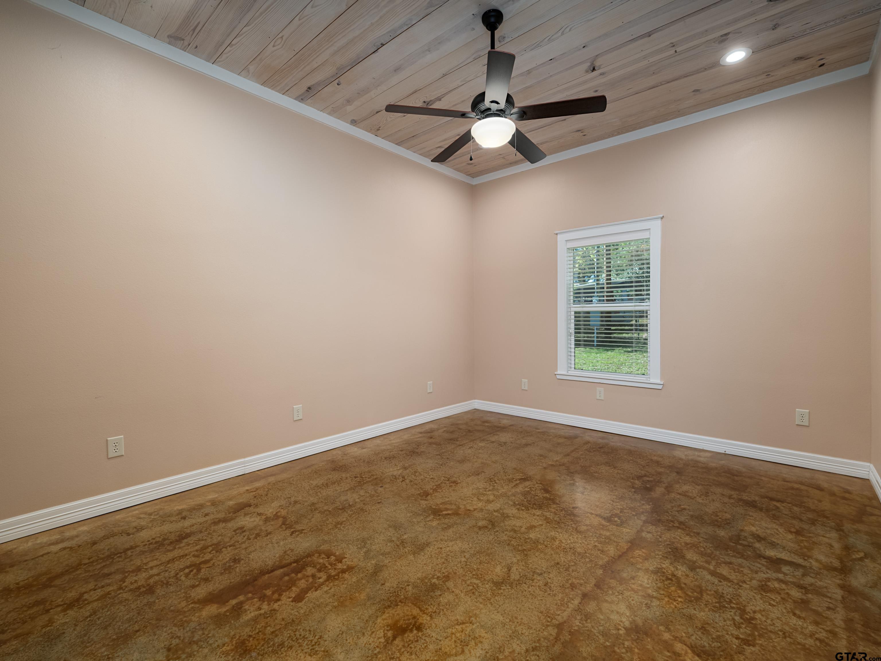 271 Front Street Palestine, TX 75803 - Photo 12 of 25 an empty room with a chandelier fan and windows