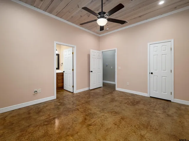 an empty room with fan and entrance