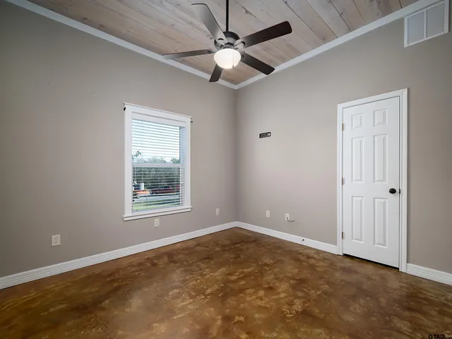 an empty room with windows and fan