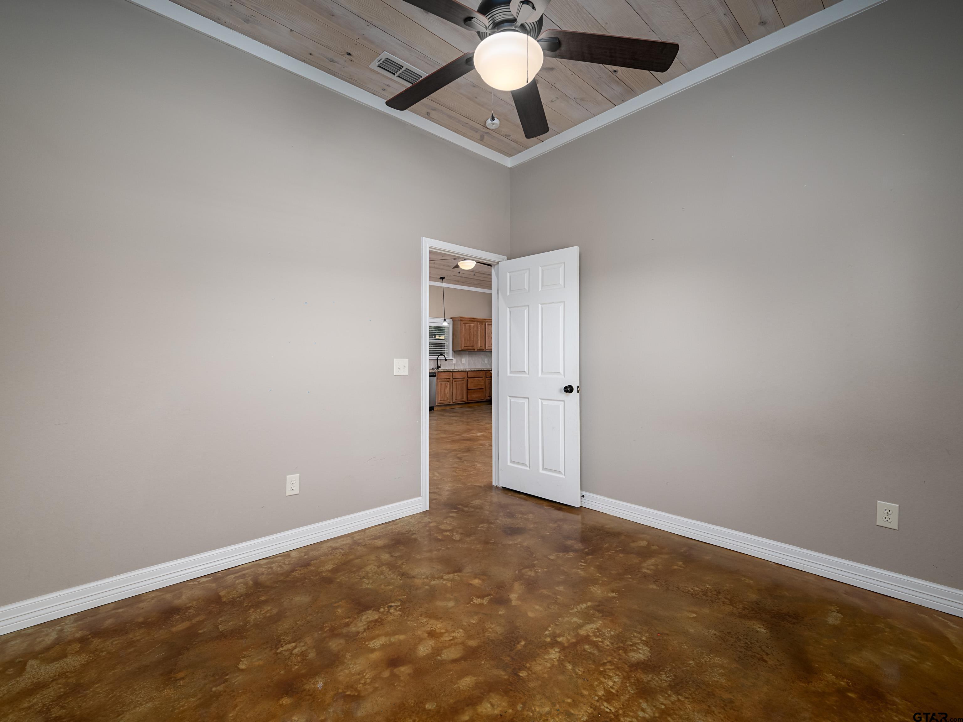 271 Front Street Palestine, TX 75803 - Photo 19 of 25 an empty room with a ceiling fan and carpet