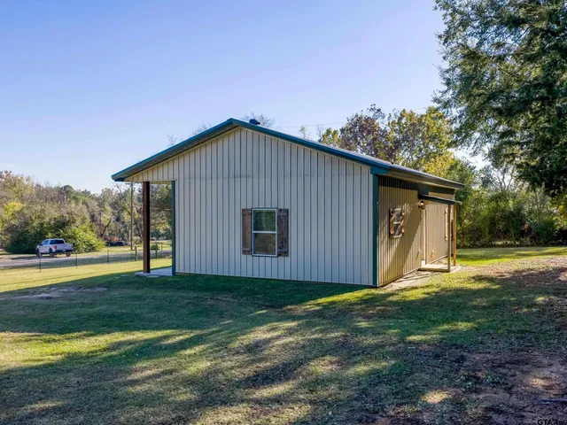 a view of a house with backyard and trees