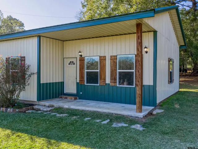 a view of a backyard with potted plants and large tree