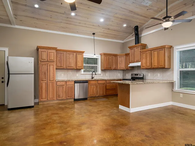 a kitchen with stainless steel appliances a refrigerator sink and microwave
