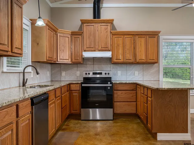 a kitchen with stainless steel appliances granite countertop a stove a sink dishwasher and a refrigerator