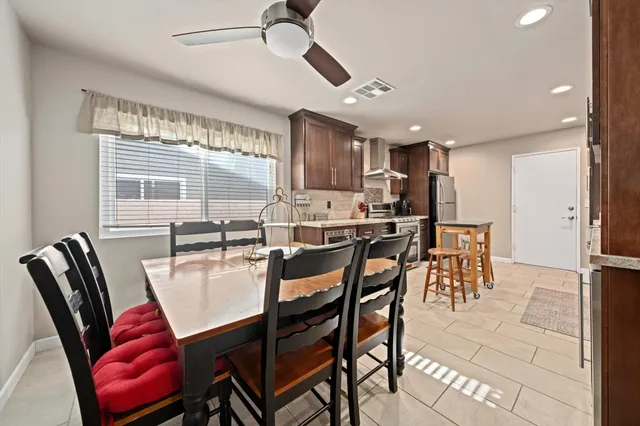 a dining area with stainless steel appliances kitchen island granite countertop furniture and a large window