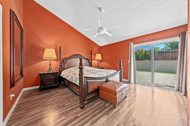 a bedroom with a bed wooden floor and window