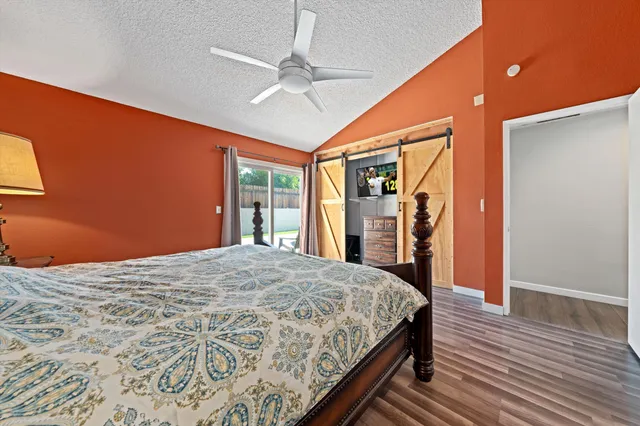 a bedroom with a large bed closet and flat screen tv
