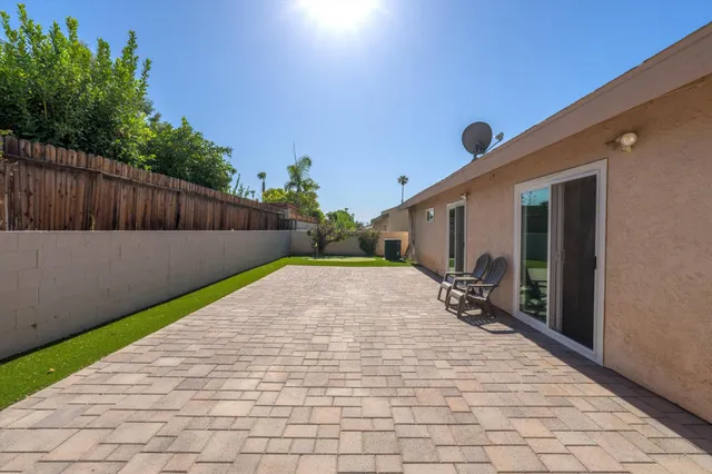 a view of backyard with wooden fence and trees