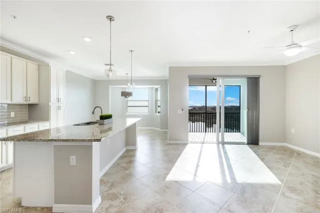 a large white kitchen with kitchen island a counter space a sink appliances and cabinets
