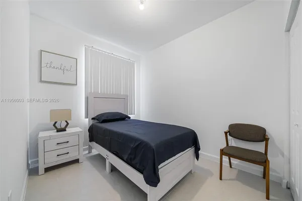 a bedroom with a bed and a lamp on table